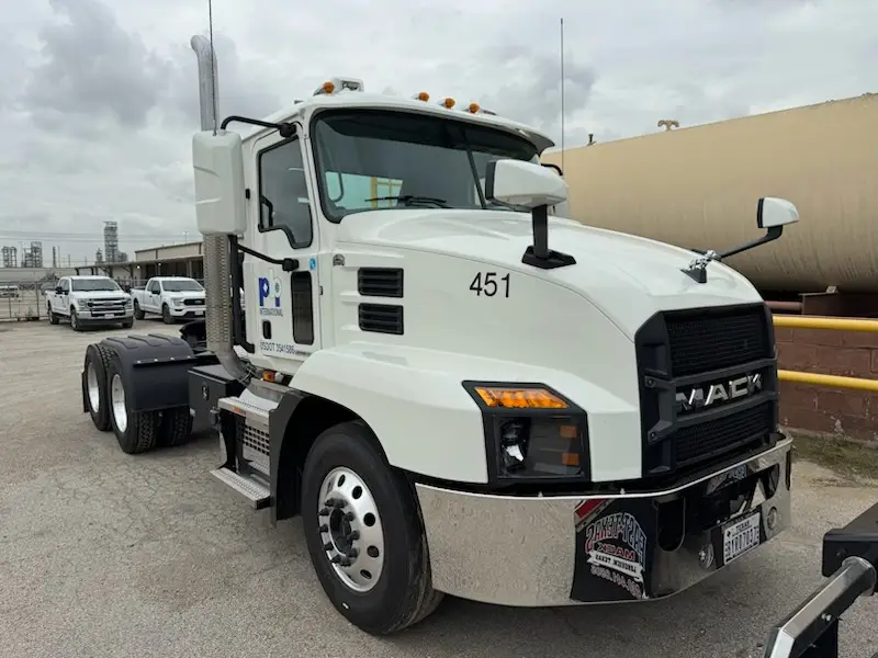 PBI International Mack truck parked at an industrial site ready for transport operations.
