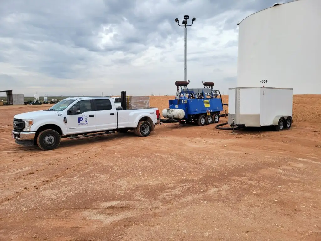 PBI International service truck and equipment trailer on-site at an industrial facility in Texas.